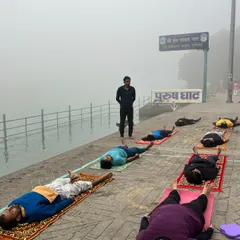 Guiding students into Savasana (deep relaxation) by the river. The sound of the flowing water enhances the restorative effect.