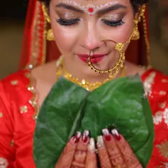 A close-up of the stunning details. This shot highlights the glittery eyeshadow, the traditional nath, and the chandan art, all essential elements of a Bengali bridal look.