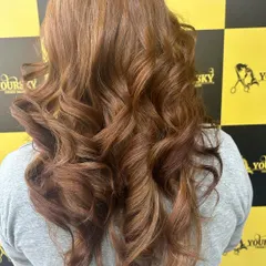 This client's global hair color in a warm copper tone looks fantastic styled with bouncy curls.
