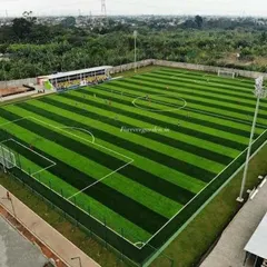 An aerial view of a full-sized football field we installed, showcasing the striped, two-tone artificial grass that mimics a professional stadium pitch.