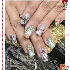 A playful and festive Christmas character set. Each nail features a different hand-painted icon like Santa, a snowman, and a reindeer over a sparkling glitter base.