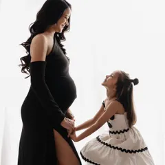 A tender silhouette of a mother-to-be and her daughter sharing a quiet moment. This image highlights the special bond they share as they anticipate the new baby's arrival.