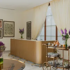 A wider view of the banquet bar area, showing how botanical artwork and fresh flowers soften the space. The design creates a seamless blend of luxury and warmth, suitable for both formal and intimate gatherings.