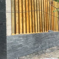 A close-up of the material palette in progress at the Good Shepherd Cathedral site. Here, we are combining natural stone cladding with vertical wooden elements to create a textured, modern facade.