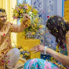 A playful flower and haldi fight between the bride and groom. These are the fun, candid moments that make a wedding memorable.