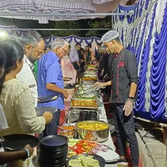 Our chef assisting guests as they choose from a variety of dishes at a housewarming party. We provide attentive service to ensure a great dining experience.