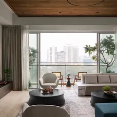 This living room is designed for comfort and sophistication, featuring my custom "Forge" TV unit with a bronze metallic finish. The expansive view is framed by custom seating, including the "Pivot" swivel armchairs that soften the room's clean lines.