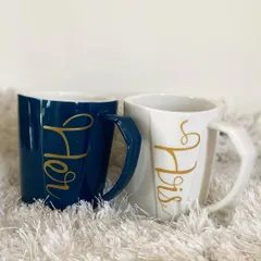 This elegant "His" and "Hers" mug set features a modern design with beautiful gold script. The contrasting navy blue and white colors make it a stylish addition to any couple's hamper.