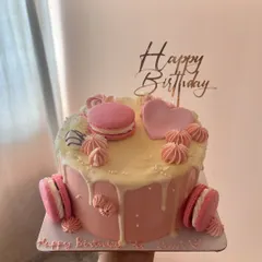 A pretty-in-pink chocolate cake. This one has a chocolate sponge, 55% dark chocolate ganache, and is decorated with pink macarons, meringue kisses, and a white chocolate drip.