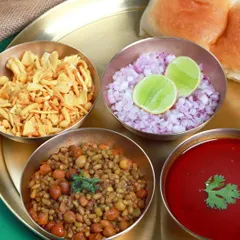 A classic Maharashtrian meal featuring Misal, served with farsan, chopped onions, and pav. The vibrant red curry (kat) and the sprouted moth beans make for a nutritious and delicious dish. This is the kind of real, unpretentious food we love to cook.