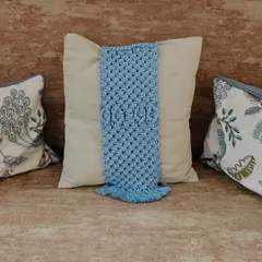 This view shows the blue tie-back on a sofa, nestled between other pillows. The detailed knotting stands out and adds a layer of visual interest to your living room decor.