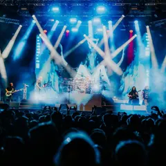 A wide shot of prog-rock legends Dream Theater commanding the stage during their 40th Anniversary Tour in India. The complex light show and massive audience highlight our capability to produce large-scale international rock concerts with precision.