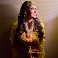 A candid shot of the bride smiling, bathed in warm light during her Haldi ceremony. I use professional lighting to create a beautiful glow, even in indoor or evening settings.
