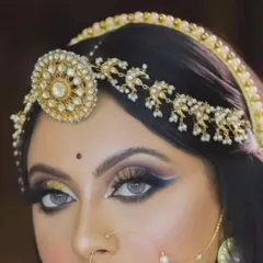 A close-up of a model wearing a traditional Rajasthani borla. This round headpiece is a signature element of the Rajputi bridal look.