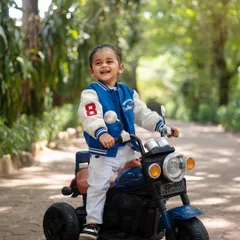 Cruising into year two with style. This little biker boy is all smiles on his miniature motorcycle, a perfect action shot for a toddler's birthday photoshoot.