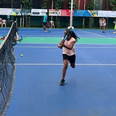 A young athlete practices her volleys at the net. Our drills emphasize quick reactions and precise racket control, essential skills for dominating the front of the court.