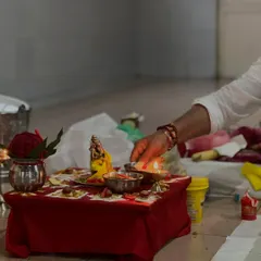 Lighting the lamp during a puja. The flame symbolizes the light of knowledge dispelling the darkness of ignorance.