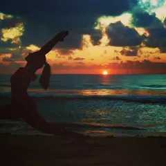 Practicing Virabhadrasana, or Warrior Pose, on the beach as the sun sets. For me, connecting with nature is a powerful way to reset and find gratitude for the beauty around us.