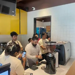 Perfecting the basics is crucial. Here, I'm demonstrating proper tamping technique, a fundamental step in achieving a balanced espresso shot, during a staff training session.