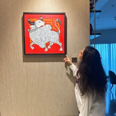 Art should tell a story. This hand-painted canvas, with its bold red background and traditional Indian bull motif, adds a powerful pop of color and culture to this contemporary space.
