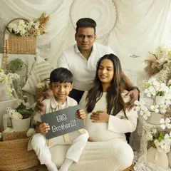 "Big Brother!" This proud older sibling announces his new role in a fun and heartwarming family portrait. It's a perfect way to include the whole family in the maternity journey.