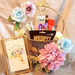 A congratulations hamper perfect for any achievement. This golden wire basket is filled with chocolates, treats, and a beautiful photo frame to hold a special memory.
