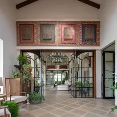 The grand entrance of our Alibaug holiday home sets a tone of arrival and wonder. We framed the view with towering glass doors and celebrated Indian craftsmanship with large-scale Naga panels, creating a space that feels both expansive and deeply rooted in cultural heritage.