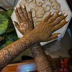 The crossed-hands pose shows how the intricate patterns flow seamlessly from the palms to the arms. This full-coverage look is a favorite among my brides.