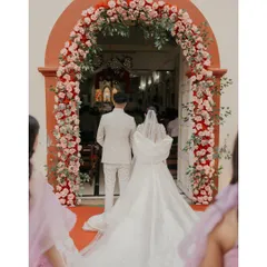 The newly married couple stands at the floral-adorned entrance of the church, ready to step into their new life together.