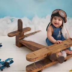 Ready for takeoff. This aviator theme, complete with a vintage wooden plane and pilot hat, is a popular choice for an adventurous sitter session.
