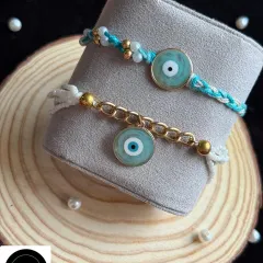 Ward off negativity with this stylish evil eye Rakhi set. The modern design combines the protective charm with a gold chain for the bhabhi and a simple thread for the bhaiya.