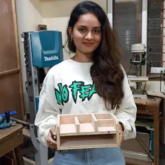 An interior design student with the desk organizer she designed and built during a one-day experiential workshop.