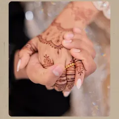 A close-up on the bride's hand, adorned with beautiful mehndi and her new engagement ring, held lovingly by her fiancé. This shot emphasizes the commitment made.