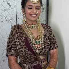 A candid moment of pure joy. This bride's smile lights up the frame, showcasing a natural and dewy makeup look that perfectly complements her intricate bridal jewelry.
