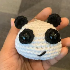 A closer look at the panda head charm, showing the detailed stitching and cute embroidered smile.