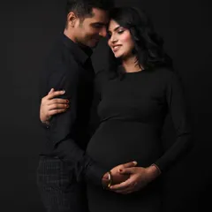 The elegance of a monochrome palette. This couple's portrait in matching black outfits is sophisticated and puts all the focus on their loving expressions and the baby bump.