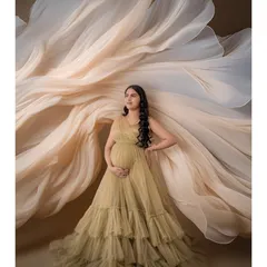 An example of our fabric art concepts, where we use flowing material to create stunning shapes and textures. Here, the fabric forms a dramatic fan behind the mom-to-be.