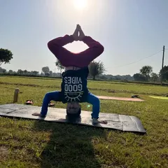 A student holding a headstand against the morning sun. Practicing inversions outdoors can feel incredibly empowering.