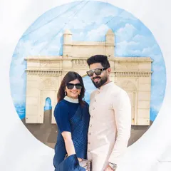 A stylish couple portrait in front of a mural of the Gateway of India. This is a great way to include an iconic landmark in your photos with a creative twist.