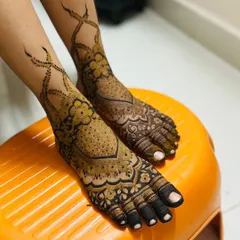 Bridal mehendi isn't complete without adorning the feet. This design features intricate floral and vine work that elegantly wraps around the ankle, ensuring you look beautiful from every angle on your special day.