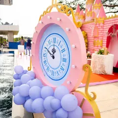It's all about the details. This oversized clock prop, set against the backdrop of a pink castle, adds a touch of Cinderella's magic, reminding everyone it's time to celebrate before the clock strikes midnight.