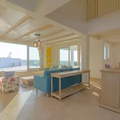 The living room in the Goa home is bathed in natural light. The design uses a neutral base with infusions of yellow and blue, while light-toned furniture maintains an airy, relaxed aesthetic perfect for a holiday retreat.