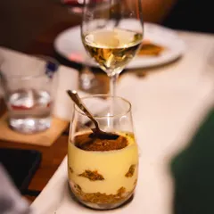 A perfect pairing of our Tiramisu with a glass of wine. It's an elegant and delicious way to end your evening with us.