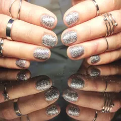 A full set of dazzling silver glitter nails on short, rounded nails for maximum sparkle.