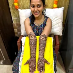 A smiling client proudly displaying her intricate full-arm mehandi. Seeing my clients happy with my work is the best reward.