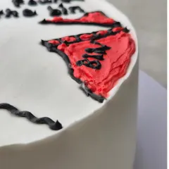 A close-up of a funny and savage birthday cake, showing the hand-piped illustration and text.