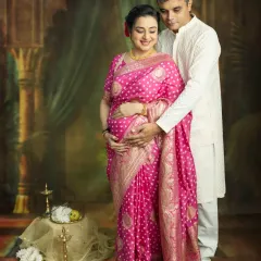 A tender moment between partners. This traditional couple's maternity shoot captures the quiet love and support you share as you await your little one, surrounded by the elegance of a classic studio setup.