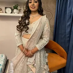 A full-length view of the stunning silver-white lehenga. The makeup is glamorous yet sophisticated, perfect for an evening of celebration.