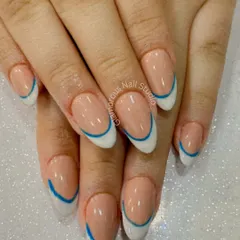 Clean, crisp, and modern. This design features a classic white French tip on an almond-shaped nail, with a striking blue line floating just above the white for a graphic, double-French look.