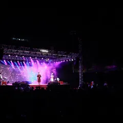 A wide shot of the "Aai Gavdevi" song release event stage at night. The combination of a large truss, powerful beam lights, and a vibrant LED screen creates a spectacular view, even from a distance.